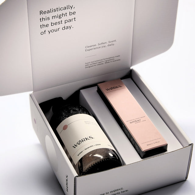 WØRKS Amber Gift Box open, showing Botanical Wash and Botanical Hand Cream inside FSC-certified packaging