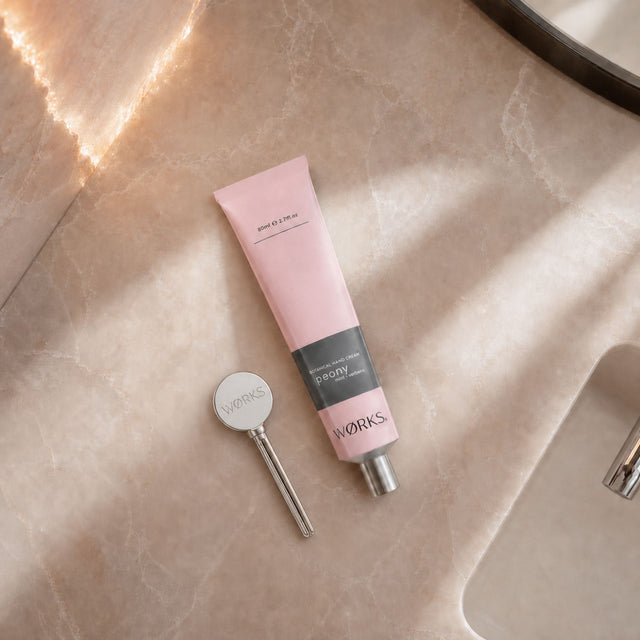 WØRKS Aluminium Tube Key styled in situ, used to roll up a WØRKS hand cream or balm tube