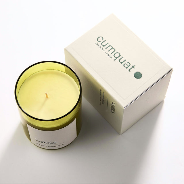 WØRKS Cumquat Aromatic Candle in smoked glass jar shown with its packaging box